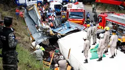 Petugas penyelamat berusaha mengevakuasi korban kecelakaan sebuah truk kargo yang menabrak bus di pinggiran Ibu Kota Honduras, Minggu (5/2). Kepolisian setempat mengatakan sopir truk melarikan diri setelah kecelakaan itu. (AP Photo/Fernando Antonio)