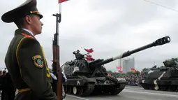 Tentara Belarus memberi hormat saat mengendarai tank dalam sebuah parade militer menandai Hari Kemerdekaan di Minsk (3/7). (AFP Photo/Sergie Gapon)