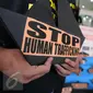 Poster bertuliskan Stop Human Trafficking' saat aksi protes di depan Kemenaker, Jakarta, Jumat (9/12). Sejumlah aktivis mendesak Pemerintah memperbaiki kebijakan penempatan buruh migran anak buah kapal asing di luar negeri. (Liputan6.com/Helmi Afandi)