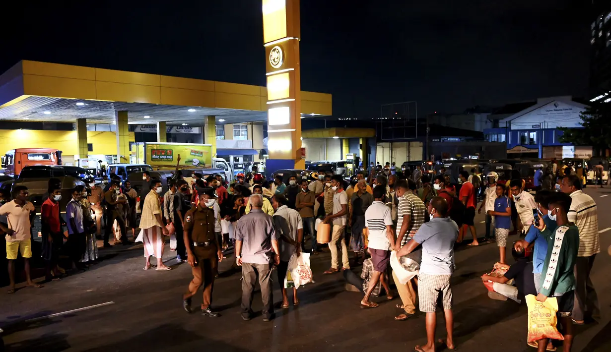Warga berkumpul di pompa bensin untuk membeli minyak tanah di Kolombo (22/3/2022). Sri Lanka memerintahkan pasukan ke pompa bensin pada 22 Maret ketika protes sporadis meletus di antara ribuan pengendara yang mengantre setiap hari untuk mendapatkan bahan bakar yang langka. (AFP/Ishara S.Kodikara)