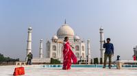 Turis mengunjungi Taj Mahal di Agra, India pada Senin (21/9/2020). Taj Mahal kembali dibuka untuk umum hari ini, Senin (21/9), dalam gerakan simbolis seperti biasa, bahkan ketika India tampaknya akan mengambil alih AS sebagai pemimpin global dalam infeksi Virus Corona COVID-19. (Sajjad HUSSAIN/AFP)