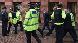 Petugas polisi mengawal Penyerang Everton Wayne Rooney di pengadilan Stockport Magpenrates di Stockport, Inggris (18/9). Polisi menangkap Rooney ketika mengemudikan mobil VW Hitam sambil mabuk di Wilmslow. (AFP Photo/Paul Ellis)