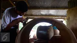 Seorang pengrajin menyelesaikan ukiran di atas kayu untuk dijadikan bedug di Desa Bleder, Ngasinan, Grabag, Magelang, Jawa Tengah, Jumat (3/6). Menjelang Ramadan, pengrajin bedug mulai kebanjiran order dari berbagai kota di Indonesia (Liputan6.com/Gholib)
