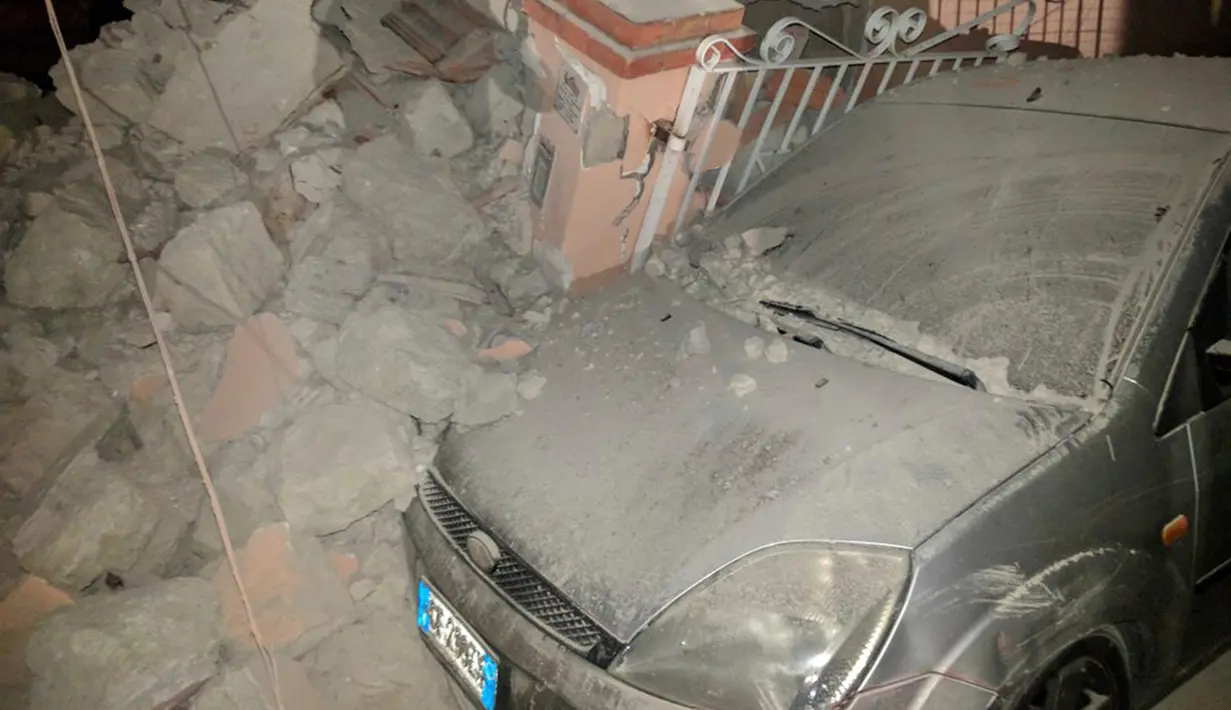 Sebuah mobil rusak terkena puing-puing reruntuhan akibat gempa di Pulau Ischia, Italia (21/8). Gempa tersebut menyebabkan sejumlah bangunan roboh dan memicu kepanikan warga dan turis. (@ Percy80 via AP)