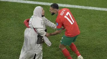 Gelandang Maroko #17 Sofiane Boufal merayakan bersama ibunya setelah lolos ke semifinal dengan mengalahkan Portugal pada babak 8 besar Piala Dunia 2022 di Stadion Al-Thumama di Doha, Sabtu (10/12/2022). Sofiane Boufal melakukan selebrasi dansa ditemani ibunya usai Maroko menang 1-0 atas. (JUAN MABROMATA / AFP)