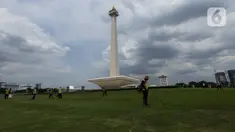 Petugas membersihkan rumput di kawasan Monumen Nasional (Monas) yang akan dijadikan arena lintasan balapan Formula E 2020, Jakarta, Selasa (11/2/2020). Formula E 2020 seri Jakarta akan memakai lintasan Monas untuk balapan mobil listrik Formula E pada 6 Juni 2020. (merdeka.com/Imam Buhori)