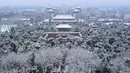 Sejumlah pengunjung (bawah) saat mengunjungi taman di dekat Kota Terlarang setelah salju turun di Beijing (30/11/2019). Beijing mengalami hujan salju pertama di seluruh kota sejak awal musim dingin dari 29 hingga 30 November 2019. (AFP Photo/Wang Zhao)