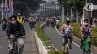 Sejumlah warga berolahraga melintas di kawasan Sudirman - Thamrin saat akhir pekan, Jakarta, Minggu (20/2/2022). Aktivitas warga di kawasan tersebut relatif ramai saat Pemberlakuan Pembatasan Kegiatan Masyarakat (PPKM) level tiga di ibu kota. (Liputan6.com/Johan Tallo)