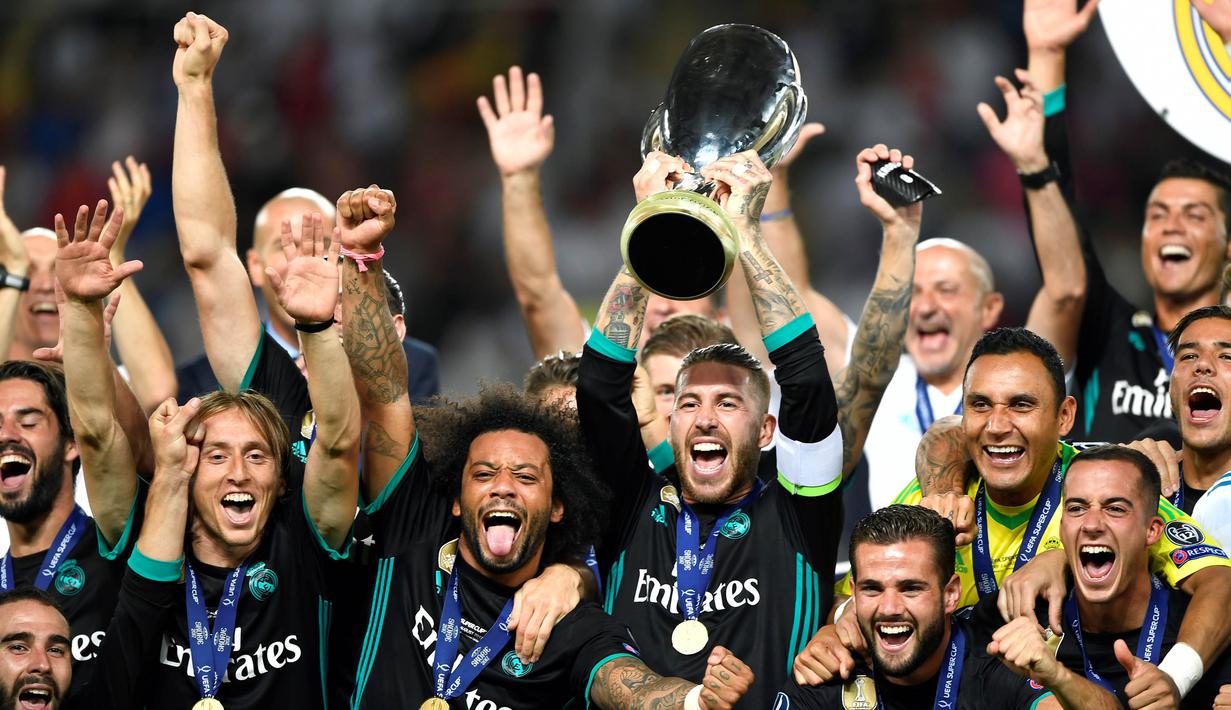 Kapten Real Madrid, Sergio Ramos, mengangkat trofi Piala Super Eropa usai mengalahkan Manchester United di Stadion Philip II, Skopje, Selasa (8/8/2017). Ini merupakan gelar Piala Super Eropa keempat bagi Real Madrid. (AFP/Dimitar Dilkoff)