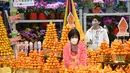 Pengunjung melihat tanaman dan bunga pada hari pembukaan pasar bunga di Hong Kong (16/1/2023). Menjelang Tahun Baru Imlek yang menandai tahun Kelinci pasar bunga di Hong Kong mulai ramai di kunjungi pengunjung. (AFP/Peter Parks)