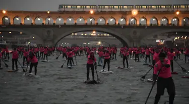 Para peserta ambil bagian dalam perlombaan dayung sambil berdiri pada Nautic SUP Paris di sepanjang sungai Seine, Paris, Prancis, Minggu (3/12). Nautic SUP Paris merupakan lomba dayung sambil berdiri terbesar di dunia. (AFP PHOTO/CHRISTOPHE SIMON)