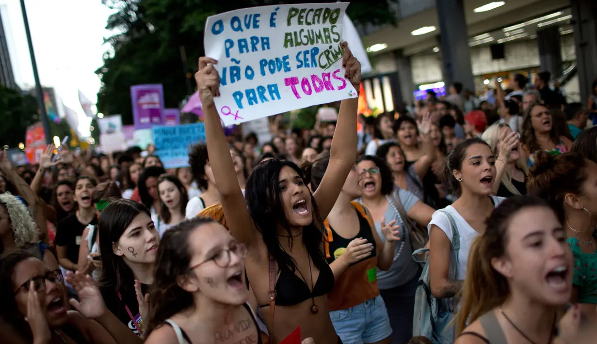 Ribuan orang menggelar protes pelarangan aborsi di Rio de Janeiro, Brasil (13/11). Sebagian dari mereka juga melakukan aksi telanjang dada sebagai bentuk protes terhadap larangan aborsi. (AFP Photo/Mauro Pimentel)