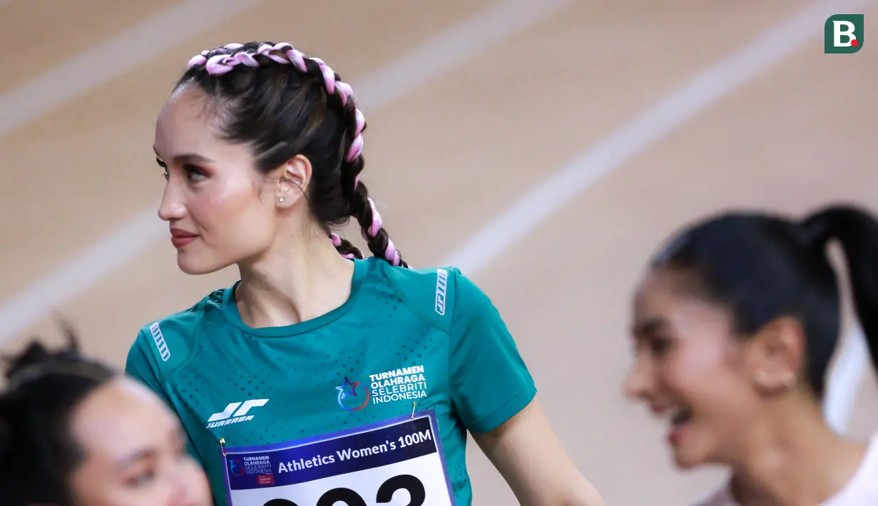Selebritas Indonesia, Cinta Laura berjalan memasuki lintasan lari sebelum berlomba pada cabang olahraga lari 100 meter putri Turnamen Olahraga Selebriti Indonesia (TOSI) di GOR UNJ, Rawamangun, Jakarta, Minggu (30/07/2023). Cinta berhasil menang dengan mencatatkan waktu 17,60 detik. (Bola.com/Bagaskara Lazuardi)