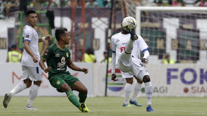 Striker Arema FC, Makan Konate, berebut bola dengan pemain Persebaya Surabaya pada laga final Piala Presiden 2019 di Stadion Gelora Bung Tomo, Surabaya, Selasa (9/4). Kedua tim bermain imbang 2-2. (Bola.com/Yoppy Renato)