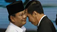 Dua calon Presiden Indonesia, Joko Widodo (Jokowi) dari Partai PDIP dan Prabowo Subianto dari Partai Gerindra saling merangkul selama sesi debat pilpres 2014 di Jakarta pada 9 Juni 2014. (AP Photo/Dita Alangkara)