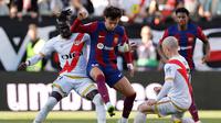 Penyerang Barcelona Joao Felix berebut bola dengan pemain Rayo Vallecano Pathe Ciss dan Isi Palazon&nbsp;dalam pertandingan Liga Spanyol di&nbsp; Estadio de Vallecas, Sabtu, 25 November 2023. (OSCAR DEL POZO / AFP)