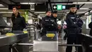 Petugas keamanan setempat menjaga lokasi terjadinya kebakaran di Stasiun Tsim Sha Tsui, Hong Kong (10/2). Akibat insiden ini, Stasiun Tsim Sha Tsui ditutup untuk sementara dan terdapat gangguan layanan di Jalur Tsuen Wan. (Handout / Apple Daily / AFP)