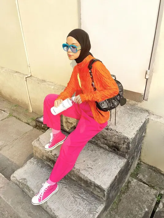 Tak perlu tangga yang estetik, tangga yang tampak biasa saja pun bisa jadi pilihan untuk berfoto. Gaya foto candid ala influencer berusia 32 tahun ini bisa jadi inspirasi ketika ingin berfoto di atas tangga. Padukan warna orange dan merah muda, penampilan istri Haykal Kamil ini makin kece apalagi ditambah dengan kacamata warna biru yang dikenakannya. (Liputan6.com/IG/@tantrinamirah)
