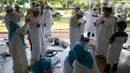 Sejumlah calon jemaah memakai kain ihram saat manasik (latihan) haji di Asrama Haji Pondok Gede, Jakarta, Senin (23/5/2022). Latihan manasik haji tersebut untuk membekali para calon jemaah haji dan umrah terkait pemahaman tata cara pelaksanaan ibadah secara mandiri ketika di tanah suci. (Liputan6.com/Herman Zakharia)