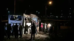 Petugas mengecek sebuah bus wisata setelah sebuah bom pinggir jalan di sebuah daerah dekat Piramida Giza di Kairo, Mesir (28/12). Bom tersebut disembunyikan di dekat dinding dan meledak secara tiba-tiba. (AP Photo/Nariman El-Mofty)