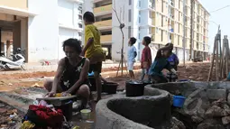 Tampak Seorang wanita sedang mencuci pakaian di halaman Rusunawa muara baru, Jakarta, Kamis (21/05/2015). Buruknya aliran air bersih membuat para penghuni Rusunawa muara baru harus mengambil air di sumur. (Liputan6.com/Herman Zakharia)