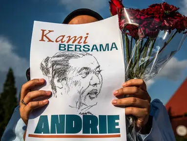 Seorang aktivis memegang poster saat demonstrasi mendukung Wakil Koordinator KontraS, Andrie Yunus, yang disiram air keras oleh orang tak dikenal, Yogyakarta, 14 Maret 2026. Wakil Koordinator Komisi untuk Orang Hilang dan Korban Tindak Kekerasan (KontraS), Andrie Yunus, mengalami serangan penyiraman air keras oleh orang tidak dikenal. (DEVI RAHMAN/AFP)