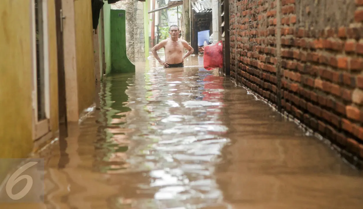 Warga memantau banjir di kawasan Cipinang Melayu, Jakarta Timur, Senin (20/2). Banjir ini merendam RW 3 hingga RW 4, Kelurahan Cipinang Melayu, Kecamatan Cipinang Muara. (Liputan6.com/Yoppy Renato)