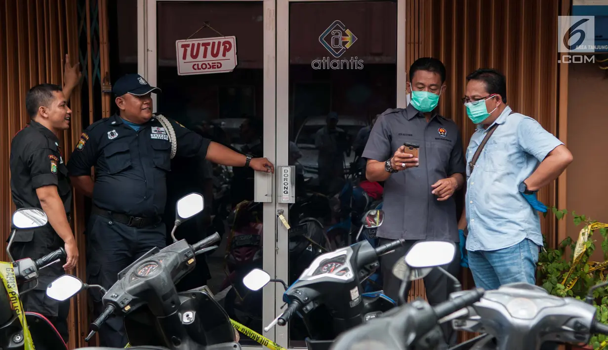 Sejumlah petugas berdiri di depan lokasi pesta gay di Atlantis Gym, Kelapa Gading, Jakarta, Selasa (23/5). Ruko tiga lantai ini dijadikan sebagai tempat pesta gay oleh 141orang pria. (Liputan6.com/Gempur M Surya)