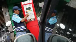 Petugas melakukan pembayaran pada mesin parkir meter di Jalan Falatehan, Jakarta, Selasa (1/11). Melalui mesin parkir meter, pemerintah mendorong penggunaan uang elektronik, khususnya untuk sektor transportasi. (Liputan6.com/Immanuel Antonius)
