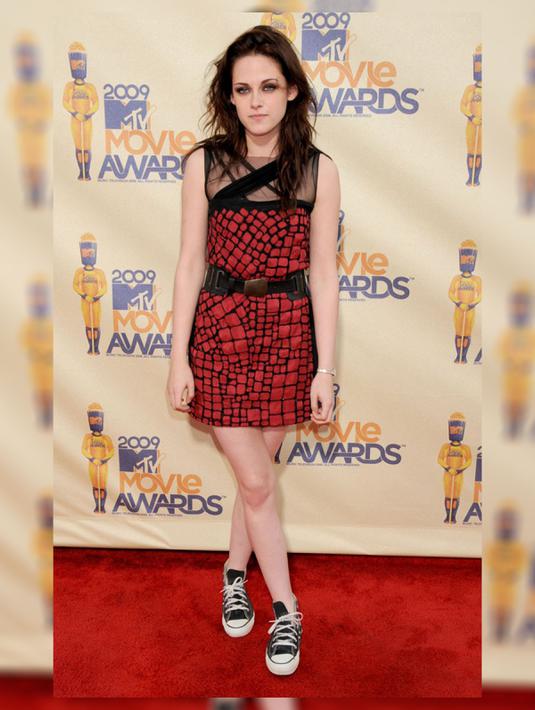 Style ini benar - benar mencuri perhatian banyak penggemar fashion di Hollywood. Kristen Stewart tampil feminim sporty dengan mini dress merah bermotif warna hitam yang cantik dan seksi. (fashionmagazine.com)