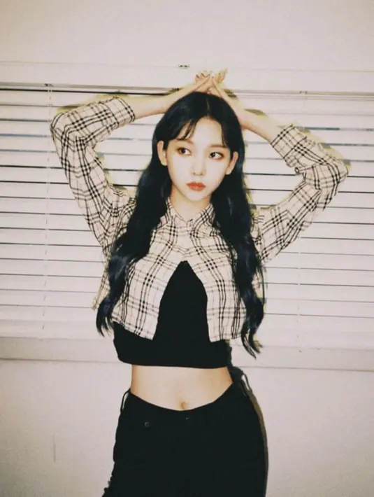 Karina tampil kece dengan cropped plaid top dan high waist pants. [@aespa_official].
