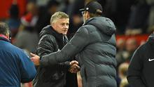 Pelatih Manchester United, Ole Gunnar Solskjaer, bersalaman dengan pelatih Liverpool, Jurgen Klopp, usai laga Premier League di Stadion Old Trafford, Manchester, Minggu (20/10). Kedua klub bermain imbang 1-1. (AFP/Oli Scarff)