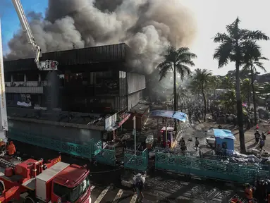 Petugas pemadam berusaha menjinakkan api yang melahap pusat perbelanjaan Pasar Senen, Jakarta Pusat, Kamis (19/1). Kebakaran yang terjadi di Blok III Pasar Senen itu berasal dari api yang timbul dari lantai satu dini hari tadi (Liputan6.com/Faizal Fanani)