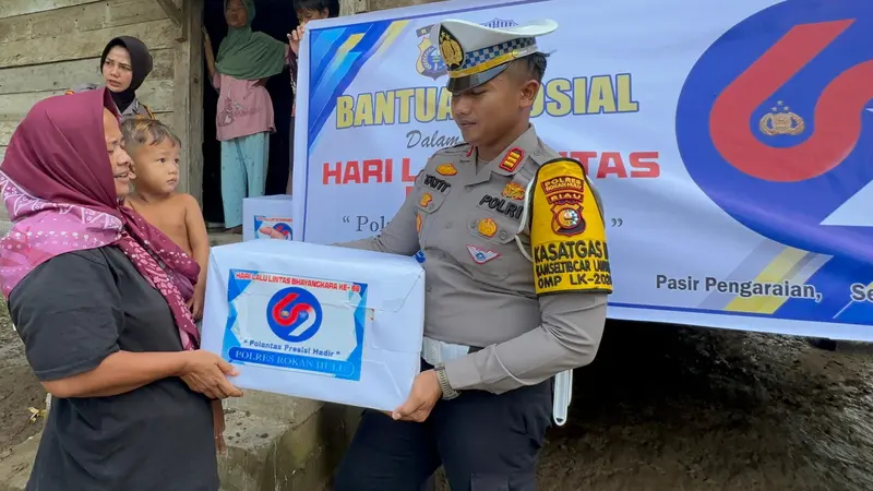 Kasat Lantas Polres Rokan Hulu AKP Tatit Rizkyan Hanafi SIK menyerahkan bantuan sembako kepada salah satu korban banjir