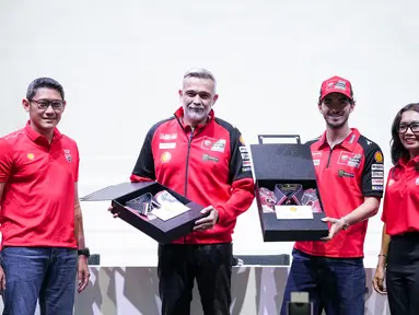 Presiden Direktur Shell Indonesia Ingrid Siburian (kanan) bersama dengan Vice President Marketing Lubricants Shell Indonesia Arie Satyanggoro (kiri) memberikan cenderamata kepada Ducati Corse Sporting Director Mauro Grassilli (kedua kiri) dan Ducati Rider Francesco Bagnaia (kedua kanan) berupa kemeja batik sebagai apresiasi dan semangat dalam rangka menyambut ajang kompetisi MotoGP 2024 pada acara Konferensi Pers Shell Advance dan Ducati Corse di Jakarta (25/09). (Dok. Shell Adavance)