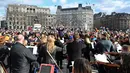 Puluhan musisi ambil bagian dalam pertunjukan flashmob "The Great Gate of Kyiv from pictures at an Exhibition" yang dipimpin seorang komposer Rusia-Inggris terkenal untuk menunjukkan dukungan terhadap Ukraina setelah invasi Rusia, di Trafalgar Square, London, Minggu (6/3/2022). (JUSTIN TALLIS/AFP)