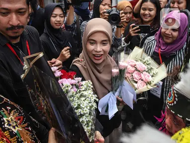 Siti Atiqoh Supriyanti menghadiri acara Hari Disabilitas Internasional yang diselenggarakan oleh Komunitas Disabilitas Tunarungu Indonesia di Bumi Pospera, Cipinang, Jakarta, Minggu (3/12/2023). Atiqoh tampak bahagia disambut oleh para penyandang disabilitas dengan rangkaian bunga. (Liputan6.com/Herman Zakharia)