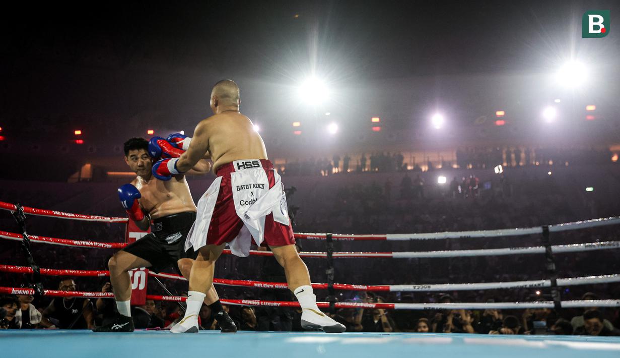 Chef Arnold (kiri) berusaha melindungi diri dari pukulan konten kreator Codeblue dalam pertarungan tinju Holywings Sports Show (HSS) seri kelima di Indonesia Arena, Kompleks Stadion Utama Gelora Bung Karno, Senayan, pada Minggu (22/04/2024). (Bola.com/Bagaskara Lazuardi)
