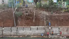 Pekerja membangun turap di bantaran Kali Cijantung, Jakarta Timur, Kamis (11/10). Pembangunan turap bertujuan mencegah longsor yang dapat membahayakan warga sekitar. (Liputan6.com/Immanuel Antonius)