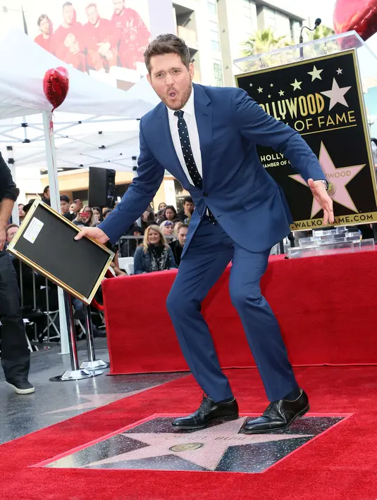 Michael Buble berpose di dekat bintang Hollywood Walk Of Fame miliknya saat acara penghargaan di Hollywood, California (16/11). Penyanyi Jazz asal Kanada ini merupakan penerima bintang ke 2,650 di Hollywood Walk Of Fame. (AFP Photo/David Livingston)