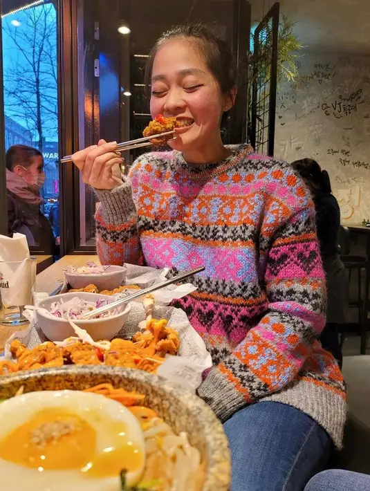 Makan malam di cuaca yang dingin, Gracia terlihat chic mengenakan sweater warna-warni yang dipadukan dengan celana jeans biru. (Instagram/graciaz14).