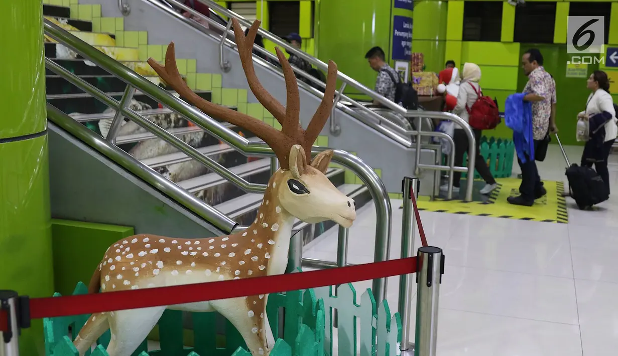 Penumpang melintas di sekitar dekorasi bertema Natal dan Tahun Baru di Stasiun Gambir, Jakarta, Jumat (21/12). Dekorasi dibuat untuk memercantik suasana Stasiun Gambir dalam rangka menyambut Hari Natal dan Tahun Baru 2019. (Liputan6.com/Immanuel Antonius)