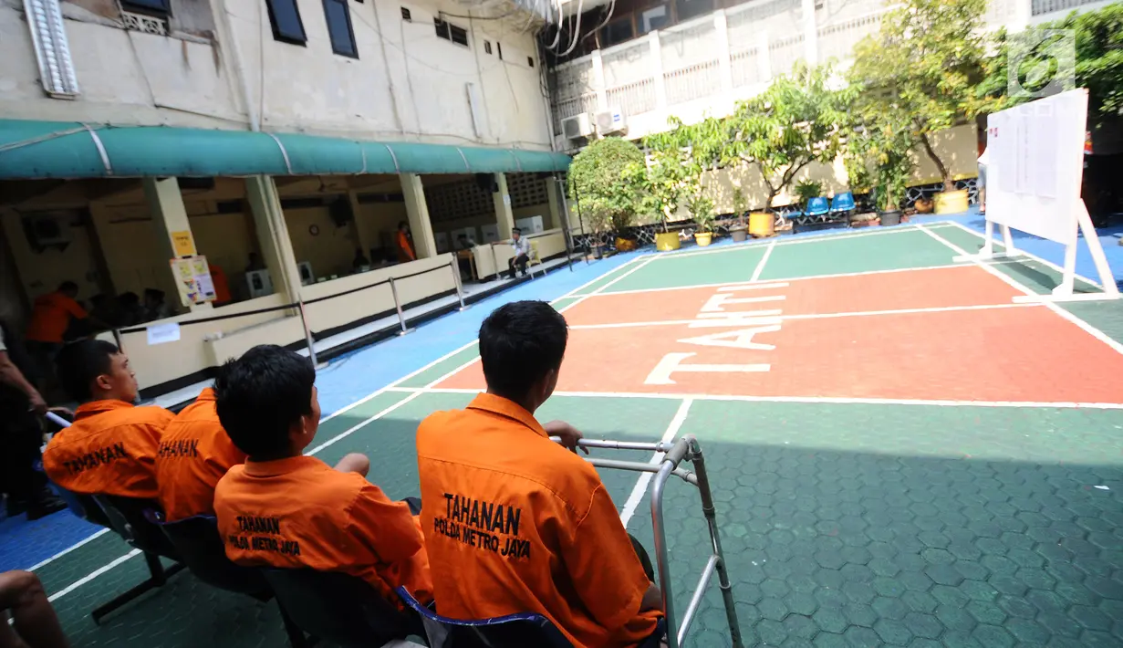 Tahanan menunggu giliran untuk mencoblos di TPS 15 Rutan Polda Metro Jaya, Jakarta, Rabu (17/4). Mereka terlihat mengenakan seragam tahanan berwarna oranye. (Liputan6.com/Herman Zakharia)