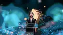 Ia nampak kenakan kebaya Kartini panjang biru navy dengan kain batik cokelat gelap dan bros di tengah [@widi.wardhana]