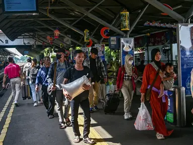 Para penumpang keluar dari stasiun kereta api setibanya mereka di Surabaya, Jawa Timur pada 6 April 2025. (JUNI KRISWANTO/AFP)