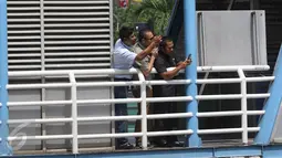 Pekerja memfoto dengan kamera ponsel rombongan Raja Salman bin Abdulaziz al-Saud saat melintas di Jalan MH Thamrin, Jakarta, Kamis (2/3). Agenda Raja Salman dimulai dari kunjungan ke gedung MPR/DPR, Masjid Istiqlal. (Liputan6.com/Immanuel Antonius) 