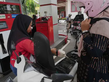 Seorang petugas mengisi tangki sepeda motor di sebuah Stasiun Pengisian Bahan Bakar Umum (SPBU) di pinggiran Jakarta, Senin 9 Maret 2026. Di tengah konflik Timur Tengah, pemerintah berencana meningkatkan infrastruktur penyimpanan hingga 3 bulan ke depan. (AP Photo/Tatan Syuflana)