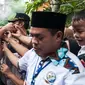 Sejumlah warga berebut hendak bersalaman dengan Calon Gubernur DKI Jakarta, Agus Harimurti Yudhoyono di Kampung Bidaracina, Jakarta, Rabu (30/1). Agus menggelar kampanye tatap muka dengan para warga di wilayah tersebut. (Liputan6.com/Gempur M Surya)