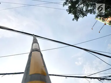 Bambu penyangga kabel terlihat di Jalan Wahid Hasyim, Jakarta, Selasa (6/11). Dua buah bambu penyangga kabel menjuntai yang sudah ada sejak beberapa hari lalu tersebut berada di tengah jalan. (Merdeka.com/Iqbal S. Nugroho)