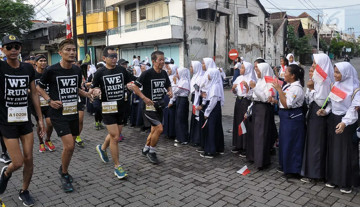 Siswi SMP memberi semangat kepada pelari yang mengikuti Semarang 10K di Kota Semarang, Jawa Tengah, Minggu (16/12). Ribuan pelari dari berbagai daerah di Indonesia ikut meramaikan lomba ini. (Liputan6.com/Gholib)